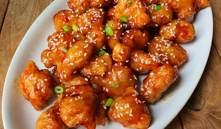 Golden, glossy General Tso's chicken sprinkled with sesame and scallion