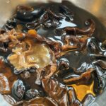 Champignons réhydratés trempés dans un bol d'eau