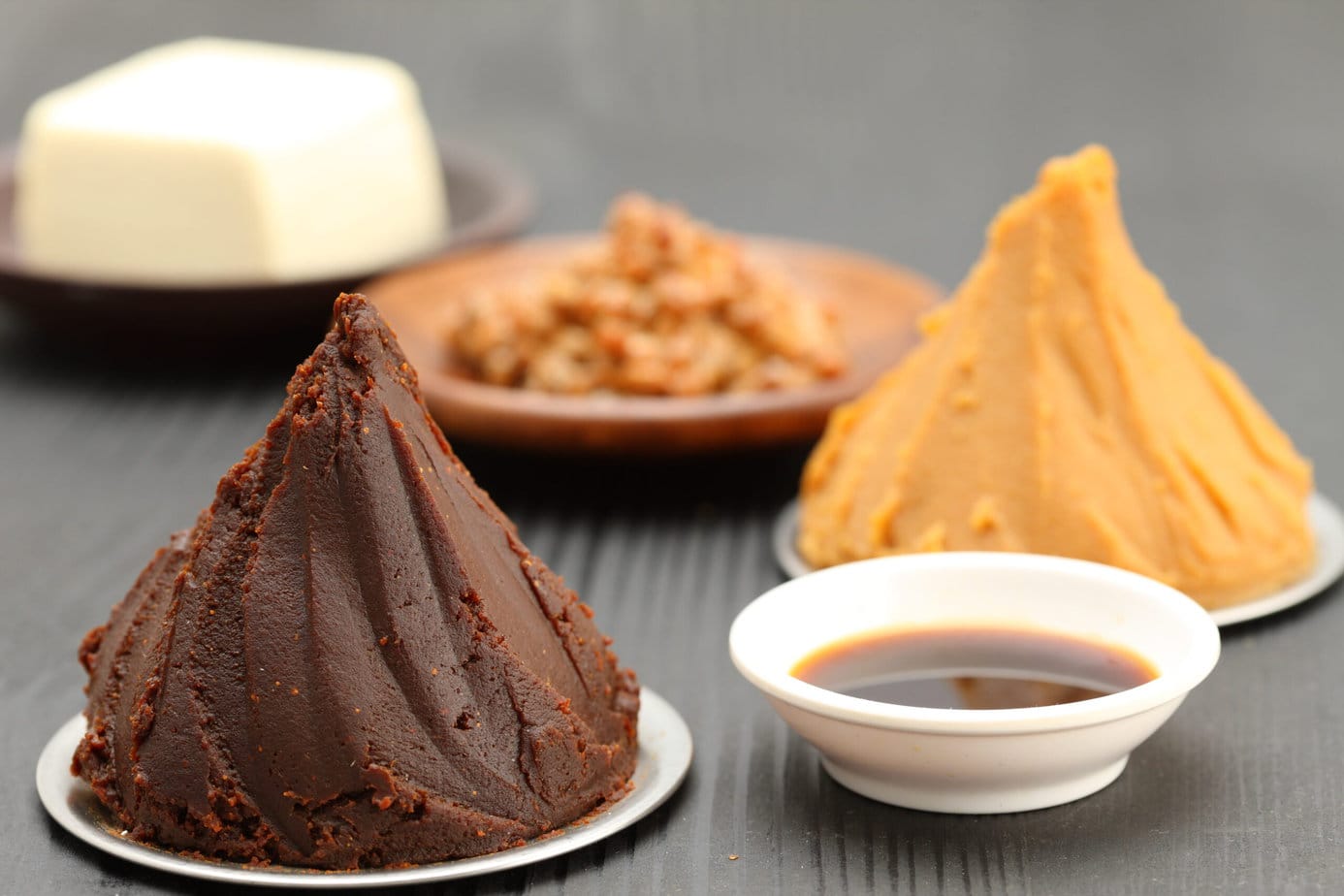 miso rouge et blanc sur table noire avec un bol de sauce soja