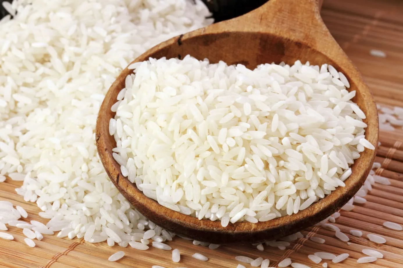 riz blanc dans cuillère en vois sur fond de bois