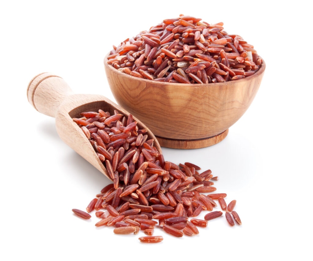 Arroz rojo sobre fondo blanco en un bol de madera