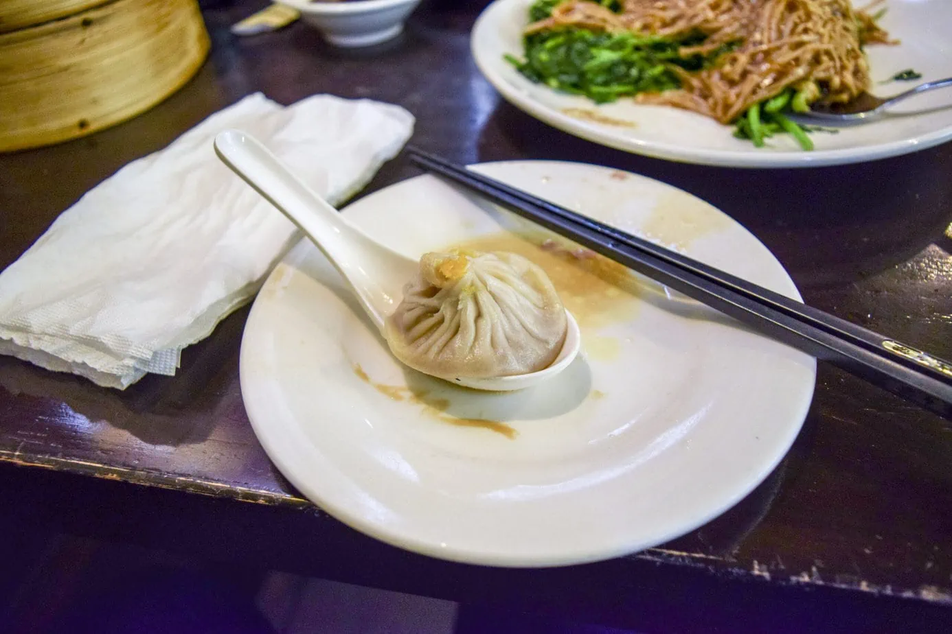 xiao long bao dans une assiette et cuillère blanche