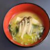 soupe miso dans un bol rouge sur fond sombre