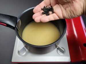 algue wakame mise dans un bouillon dans une casserole noire
