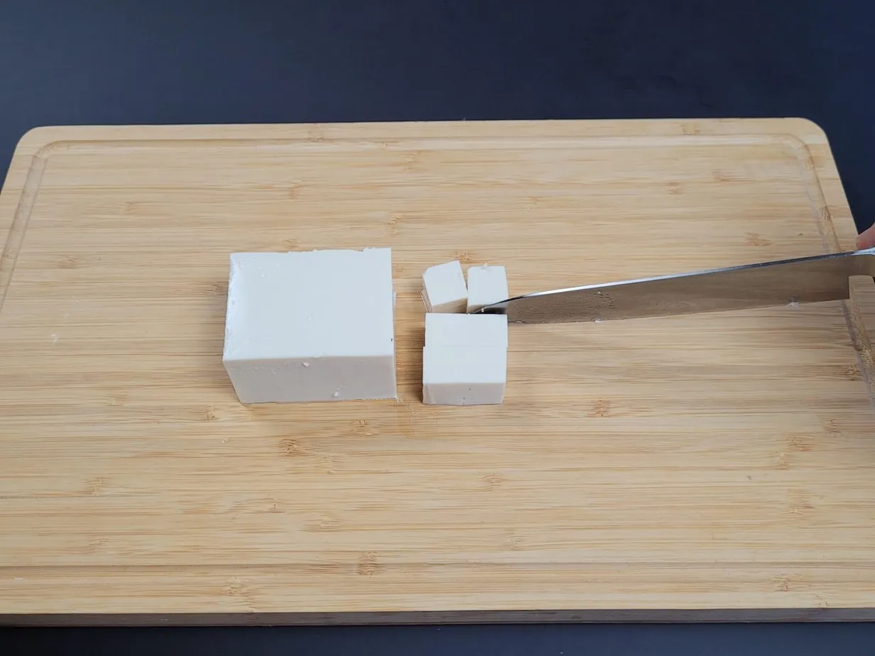 tofu blanc découpé sur une planche en bois
