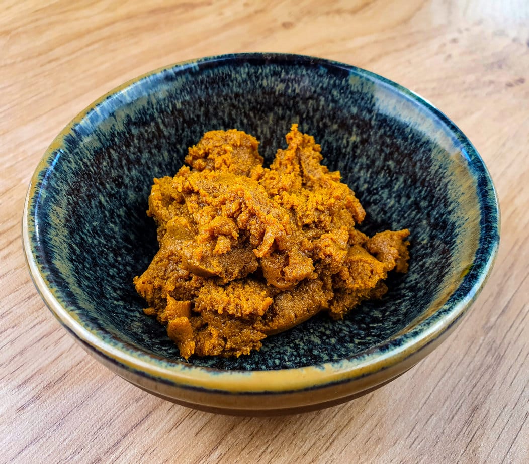 pâte de curry jaune thaï dans un bol sur fond de bois