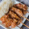 brochettes sucrées salées thaïlandaises sur une assiette avec du riz gluant