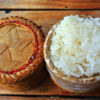 riz gluant cuit présenté dans un panier sur fond de bois