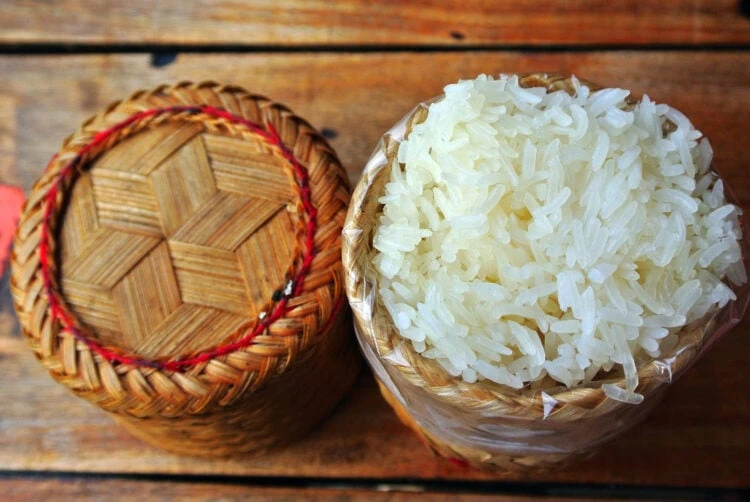 riz gluant cuit présenté dans un panier sur fond de bois