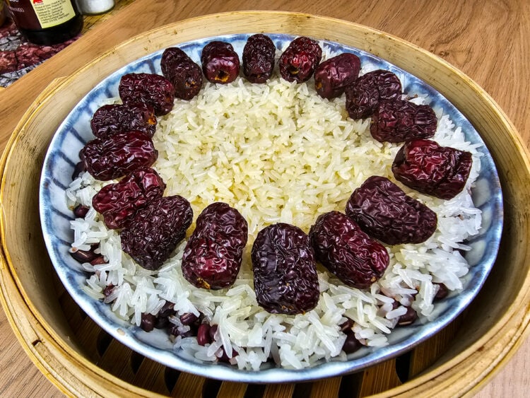 riz gluant aux haricots rouges sur fond de bois dans un panier vapeur