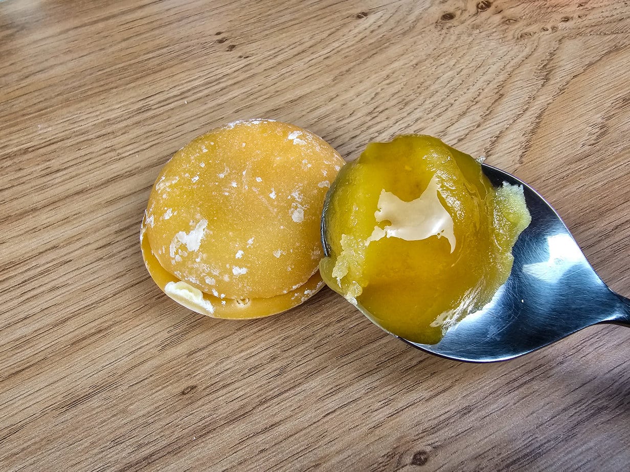 palm sugar and coconut sugar on a wooden background, with coconut sugar in a metal spoon