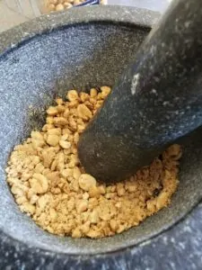 cacahuètes pilées dans un mortier