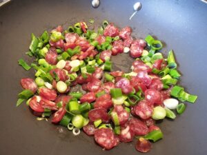 saucisse chinoise et jeunes oignons dans wok