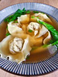 soupe wonton dans un bol sur fond de bois