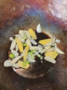 ail gingembre et jeunes oignons dans le wok