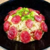 riz aux saucisses chinoises vapeur dans un bol noir