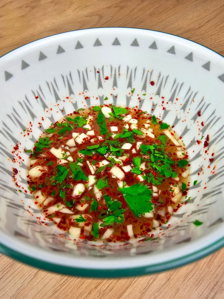 sauce nem rougeâtre dans un bol asiatique blanc sur fond de bois