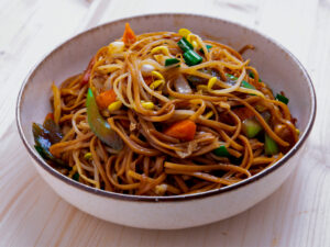chow mein sur fond de bois dans un bol blanc