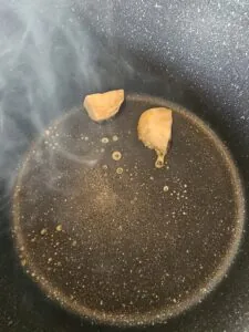 morceaux de sucre en train de fondre dans une casserole sombre
