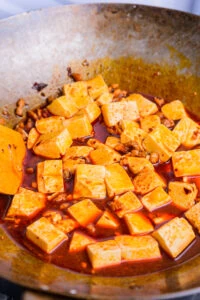 sauce fin entourant le tofu dans un wok