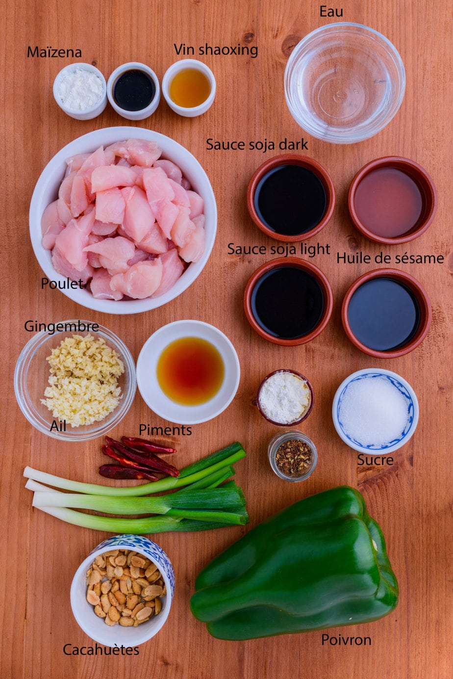 ingredients for kung pao chicken arranged on a wooden background