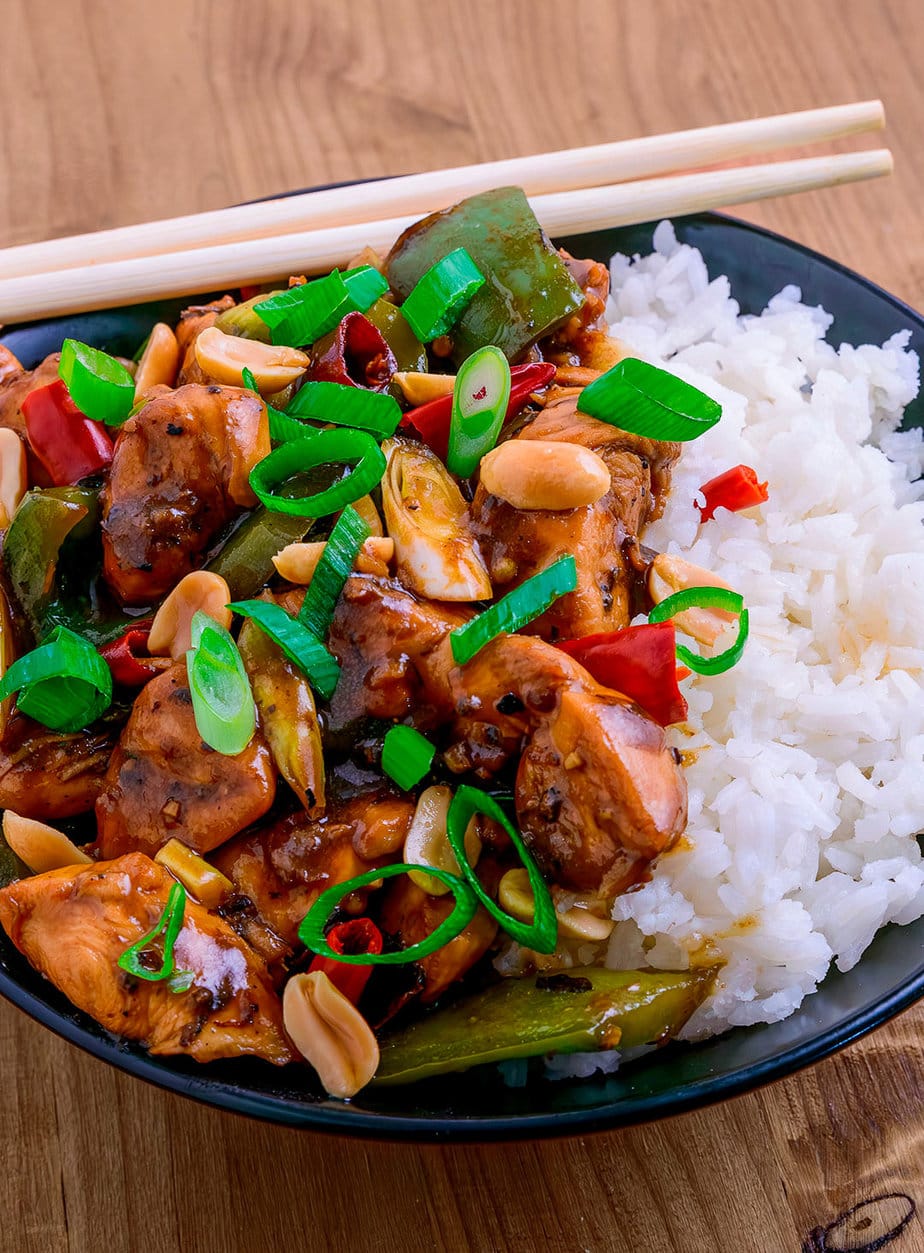 kung pao chicken on a wooden background in a deep blue plate