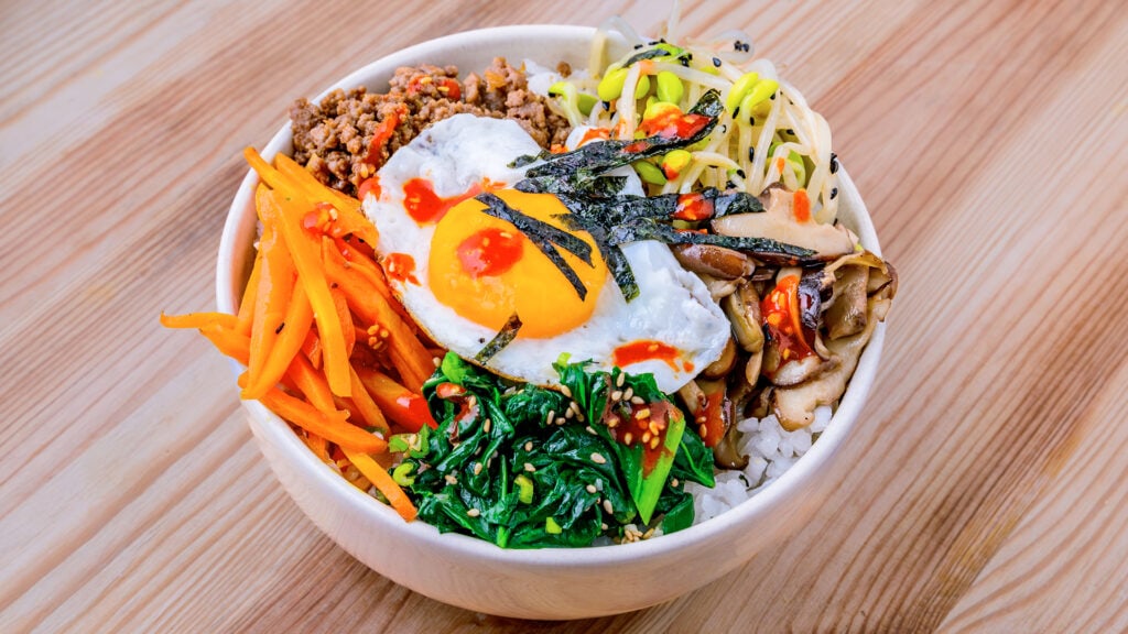Bibimbap coreano colorido, un bol de arroz con verduras y huevo
