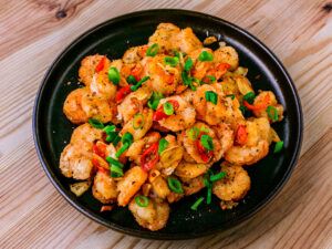 Crevettes poivre et sel sur fond de bois