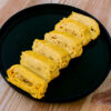 tamagoyaki sur fond de bois dans une assiette noire