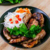 Bun cha dans un bol noir sur fond de bois