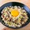 tamago kake gohan dans un bol noir sur fond de bois