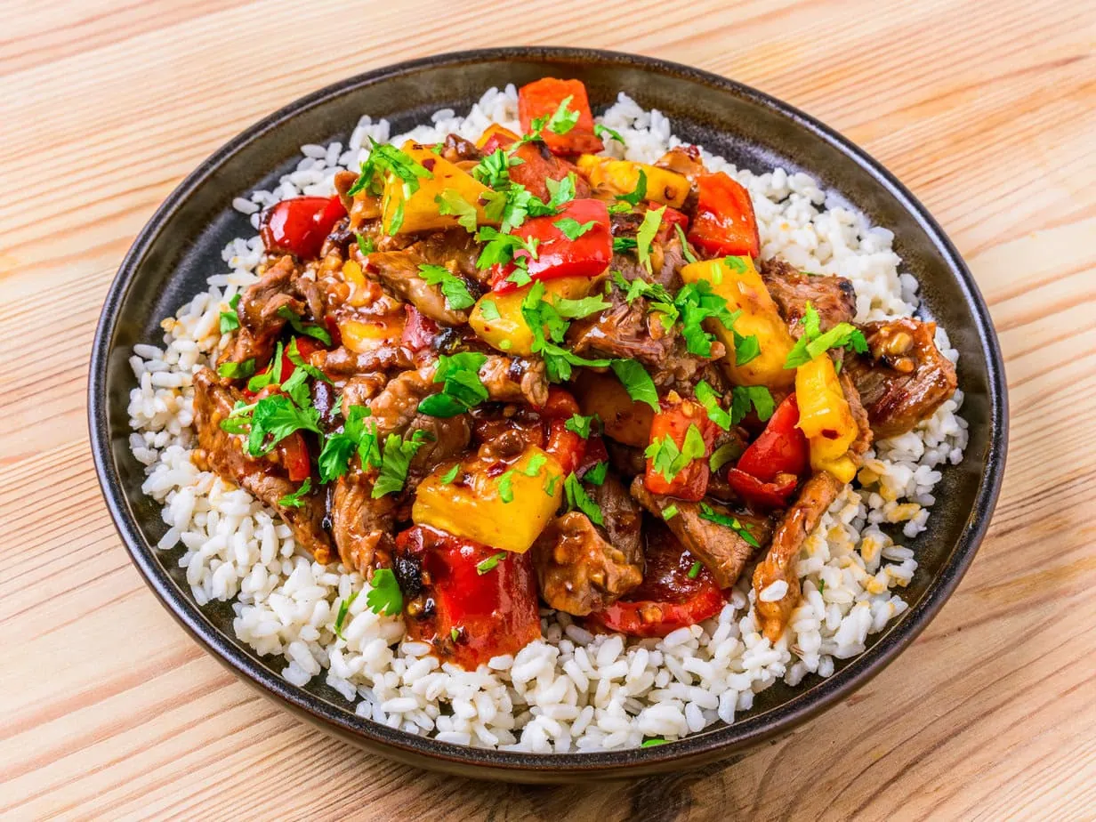 Stir-fried beef with pineapple on a wooden background