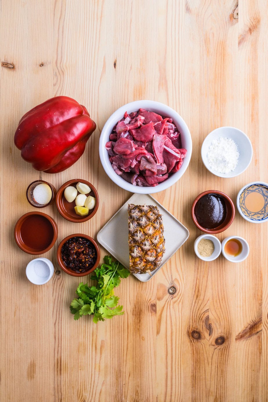 ingredients for Malaysian pineapple beef stir-fry on wooden background