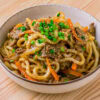 bulgogi udon dans un bol sur fond de bois