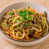 bulgogi udon dans un bol sur fond de bois