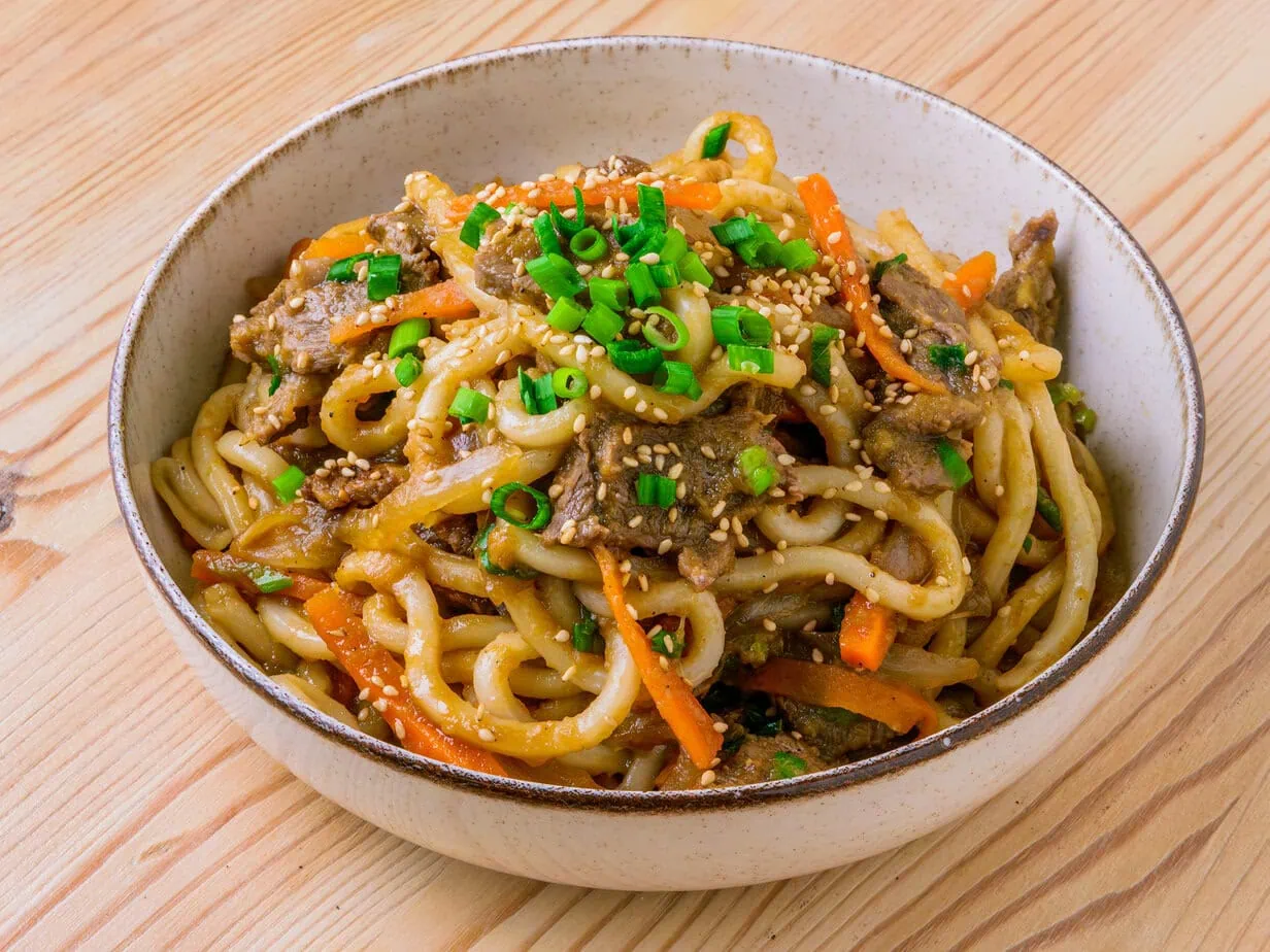 bulgogi udon dans un bol sur fond de bois