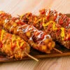 4 sortes de corn dogs coréens sur une planche en bois