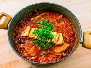 kimchi jjigae dans un bol sur fond de bois