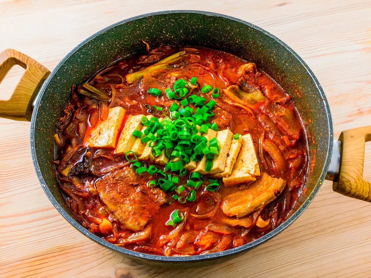 kimchi jjigae in a bowl on a wooden background