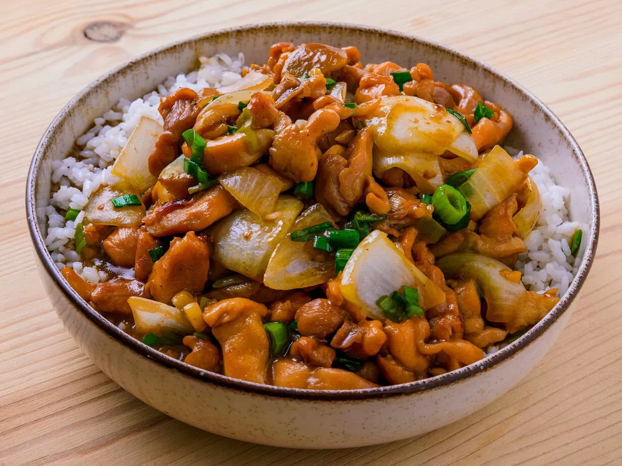 Poulet sauté au gingembre et jeunes oignons sur fond de bois