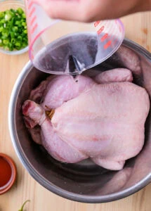 eau versée dans une casserole contenant du poulet