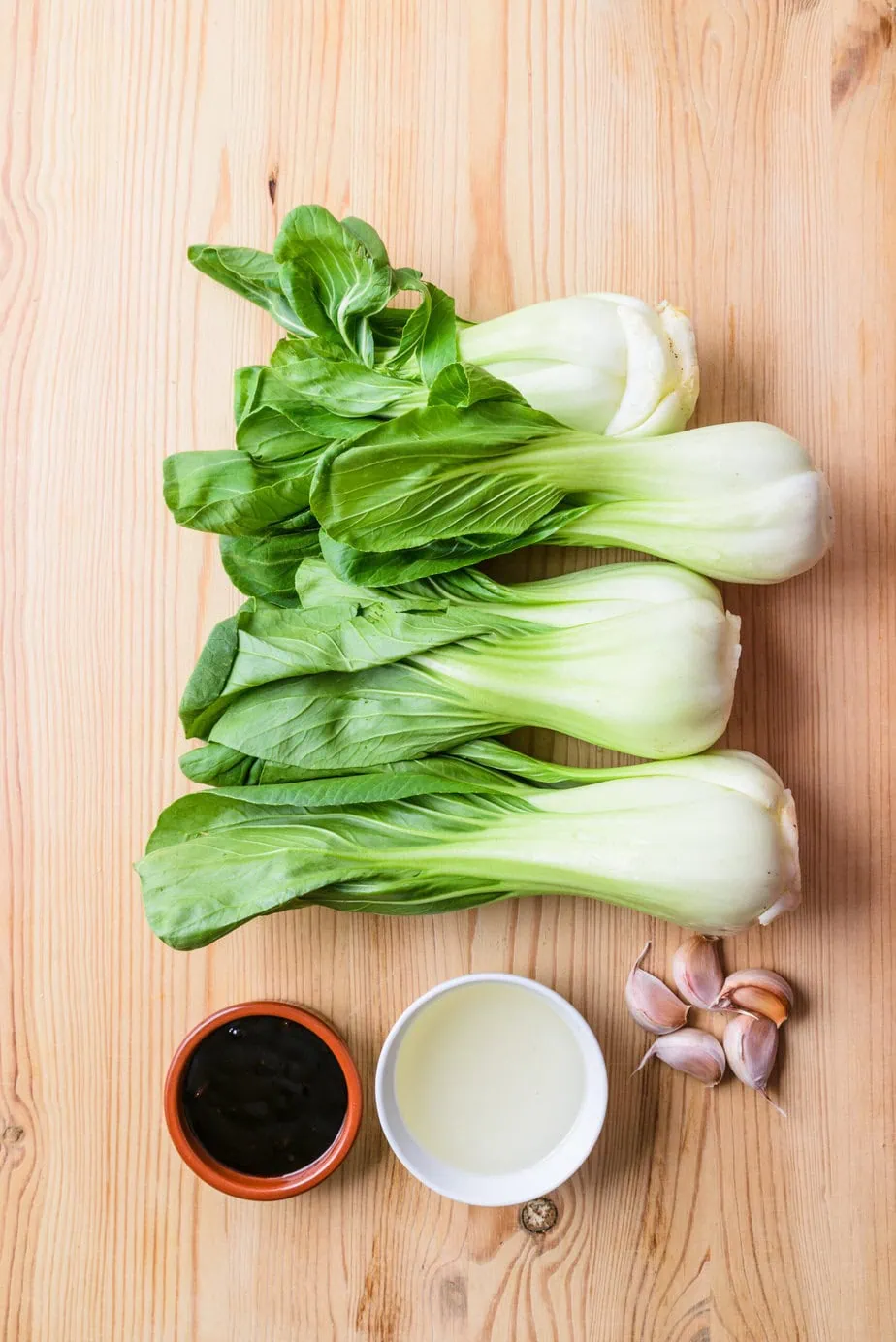 ingrédients pour pak choi sauté nature sur fond de bois