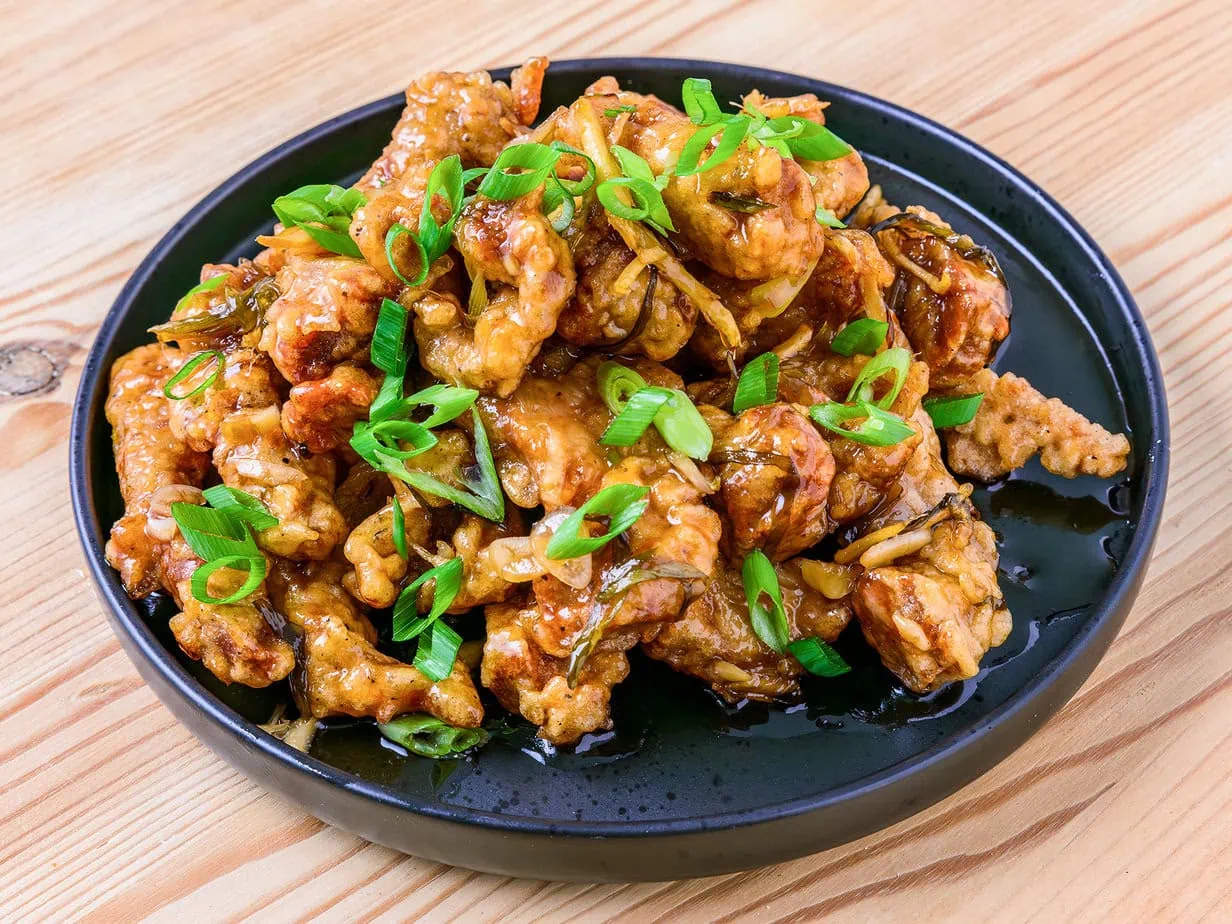 Korean fried pork with sweet and sour sauce on wooden background