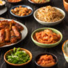 plats coréens dans des assiettes sur une table en bois noir