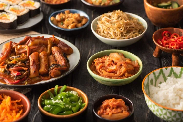 plats coréens dans des assiettes sur une table en bois noir