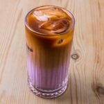 Une latte dans un verre sur fond de bois