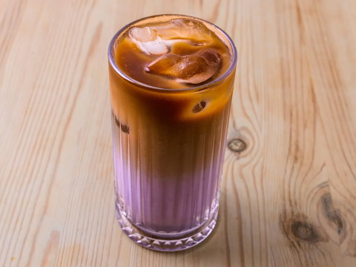 Une latte dans un verre sur fond de bois