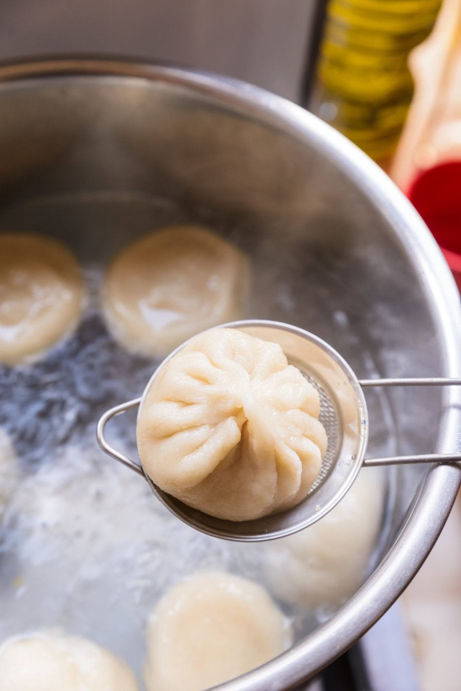 Ravioli retiré d'une casserole d'eau bouillante à l'aide d'une écumoire.