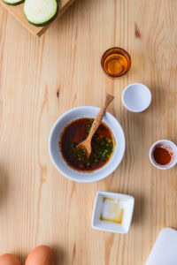 Beignets de courgette - Préparation de la sauce: Mélanger la sauce soja, l'eau, l'huile de sésame, le gochugaru et le piment émincé jusqu'à homogénéité.