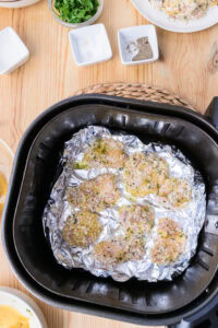 Nuggets au air fryer - Disposer la moitié des nuggets dans le panier de l’air fryer en les espaçant et vaporiser généreusement d’huile de cuisson en spray.